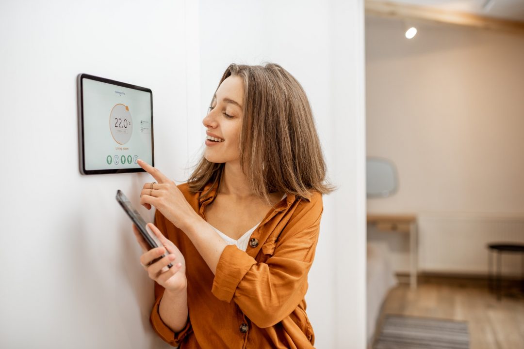 Woman controlling heating with a smart devices.jpg